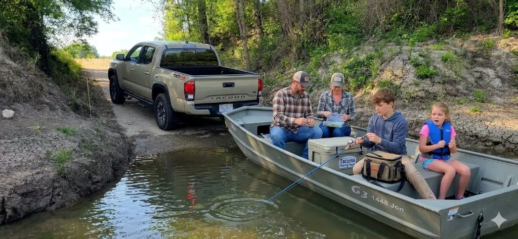 Family fishing from a G3 jon boat at the boat ramp